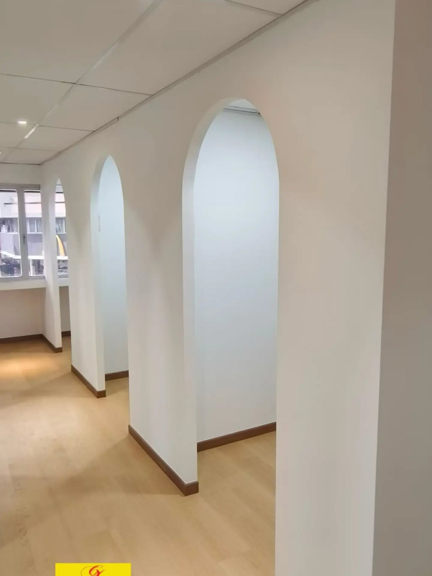 A second view along the arched-opening corridor, looking through the arches toward the rooms beyond.